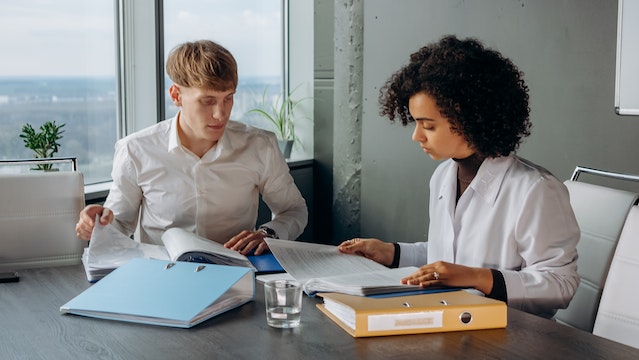 two people looking at papers in an office space