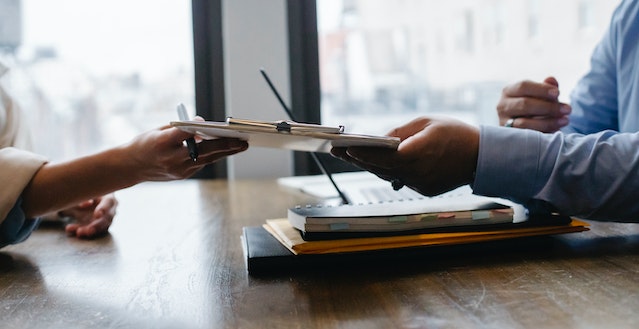 two hands holding a checklist over a table