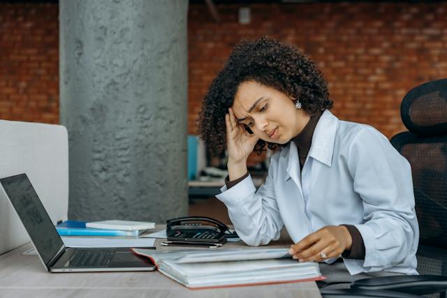 A landlord looking stressed at their laptop.