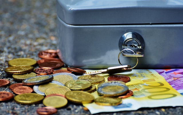 lockbox with bills and coins below it