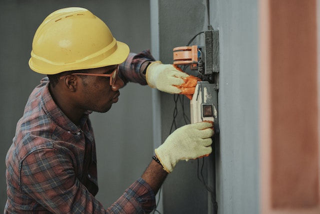 An electrician in a hard hat working.