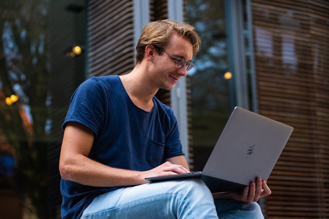 A person on a laptop smiling.
